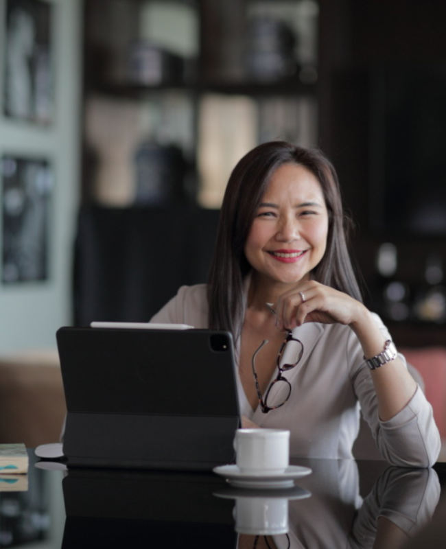 a girl seating on the table with her laptop